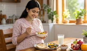 Pregnant Indian woman eating healthy home-cooked thali with dal, roti, fruits and milk